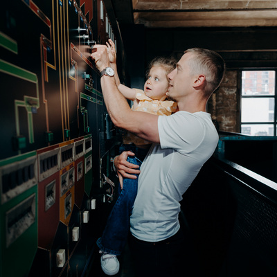 Une petite fille et un adulte manipulent un tableau interactif lors de la visite